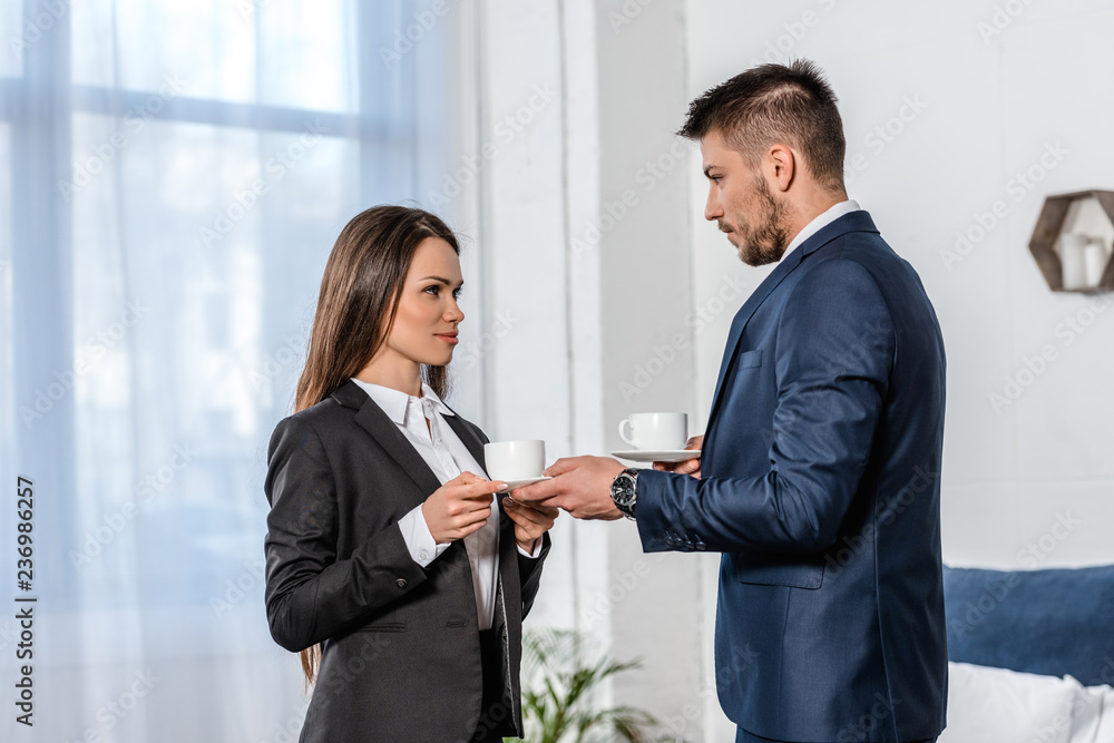handsome boyfriend giving cup of coffee to attractive girlfriend in morning at home handsome boyfriend giving cup of coffee to attractive girlfriend in morning at home