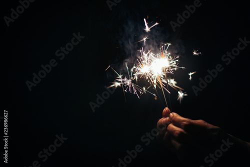 Beautiful sparklers in my hands on black background,holiday and xmas and new year concept.