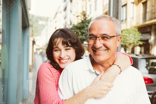 Portrait of happy father and daughter embracing on the street photo