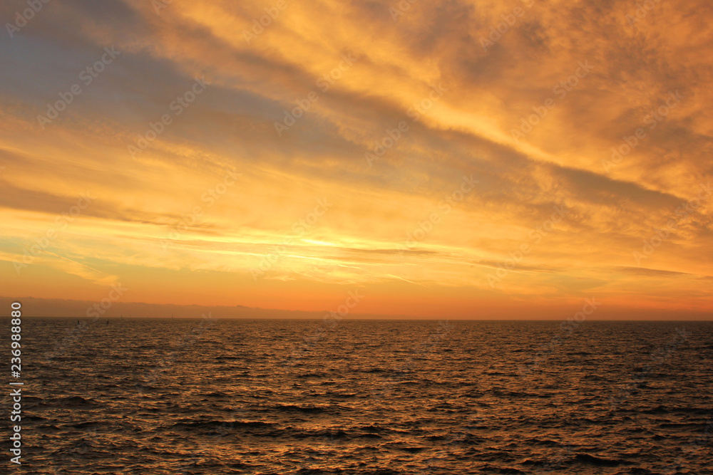 Sky Nature View of Sunset Over Calm Sea Water with Light Soft Cloudscape. Beautiful Sky Background at Sunset or Sunrise, Dusk or Dawn Panoramic Skyline View with Still Water on Summer Season Day
