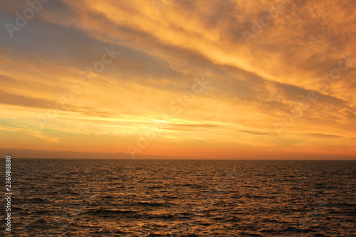 Sky Nature View of Sunset Over Calm Sea Water with Light Soft Cloudscape. Beautiful Sky Background at Sunset or Sunrise  Dusk or Dawn Panoramic Skyline View with Still Water on Summer Season Day