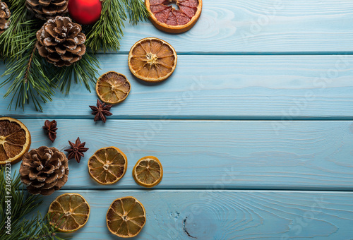 Christmas baskground with handcraft dry decoration slices of orange, fir cones on a wooden blue background. Flat lay