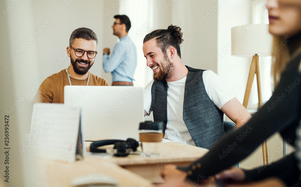 © Halfpoint - Group of young businesspeople with laptop working together in a modern office. © Halfpoint - Group of young businesspeople with laptop working together in a modern office.