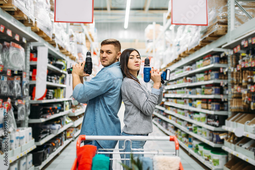 Couple with electric screwdrivers, power tools photo