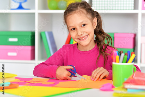 Portrait of cute little girl gluing paper