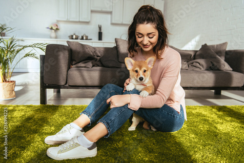 Valokuva joyful woman with cute welsh corgi pembroke at home