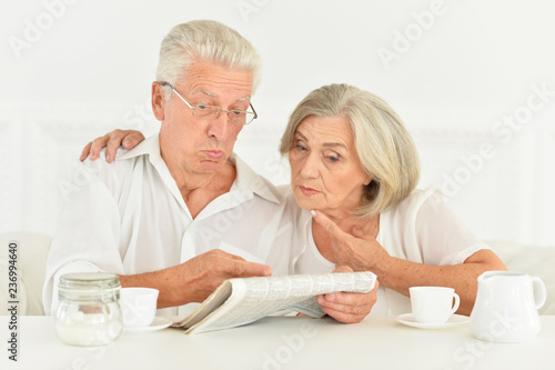 Close-up portrait of a senior couple with newspaper