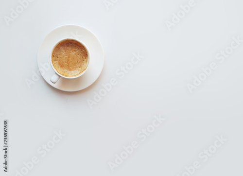 Cup of coffee - top view minimalist composition on a white background. White mug with espresso, flatlay
