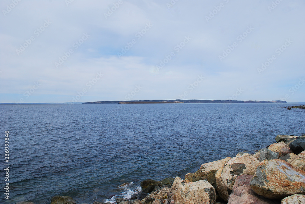 Looking across Conception Bay at Kelly's Island, and Bell Island. Rocky beach in foreground, islands in background. Conception Bay South, Newfoundland.