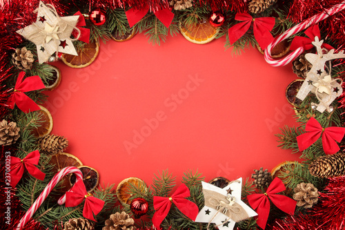 Christmas and New Year frame for text with a Christmas tree and colored Christmas decorations on a red bright background. view from above.