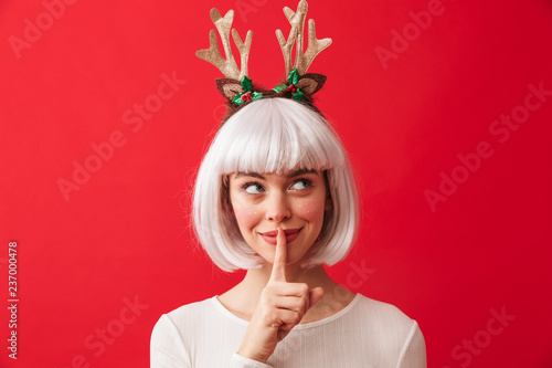 Cute woman isolated over red wall background wearing deer ears costume carnival showing silence gesture.