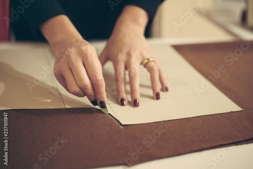 Tailor at work, drawing line on fabric with chalk photo