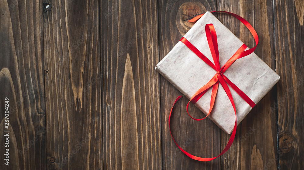 gift with red ribbon on the wooden table gift with red ribbon on the wooden table