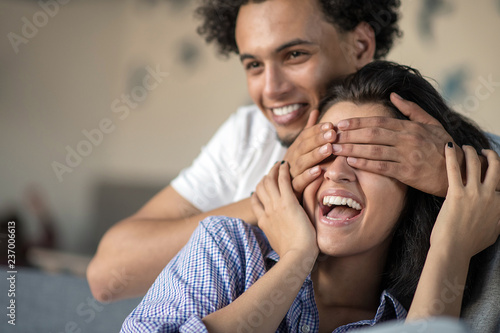 Young black couple relaxing on couch and smiling at camera