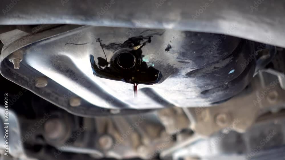 The oil is flowing from the engine under the car while the engine oil changes. To maintain and extend the life of the car. The oil is flowing from the engine under the car while the engine oil changes. To maintain and extend the life of the car.