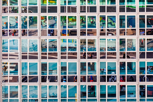 facade of office building with reflection of street life