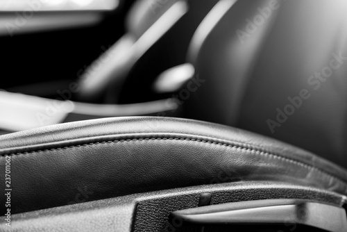 Modern luxury car black perforated leather interior. Part of leather car seat details. Modern car interior details. Car detailing. Electronic control buttons. Black and white