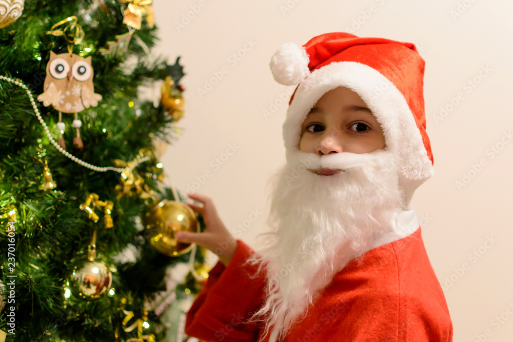 Merry Christmas holidays Santa boy near beauty fir tree Merry Christmas holidays Santa boy near beauty fir tree