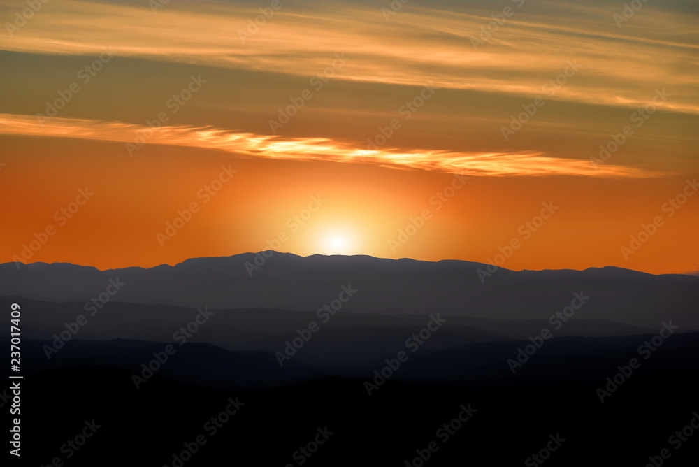 Fototapeta premium A beautiful sunset behind the silhouette of a mountain