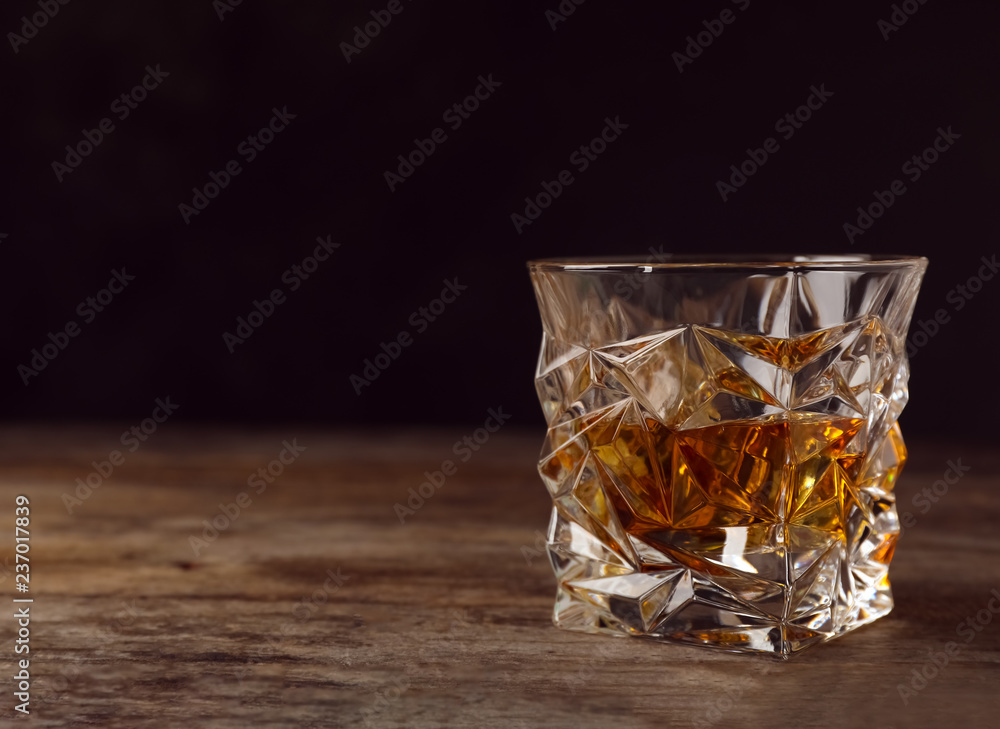 Golden whiskey in glass with ice cubes on table. Space for text Golden whiskey in glass with ice cubes on table. Space for text