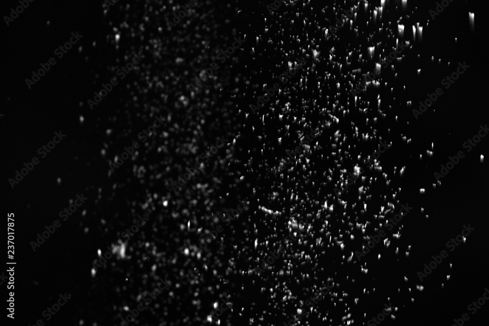 Snow flakes falling on black background. Winter weather