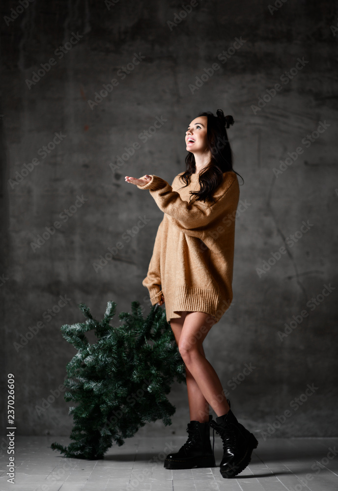 Sexy hipster woman hold Christmas fir tree in knitted sweater blouse ready for New Year Celebration