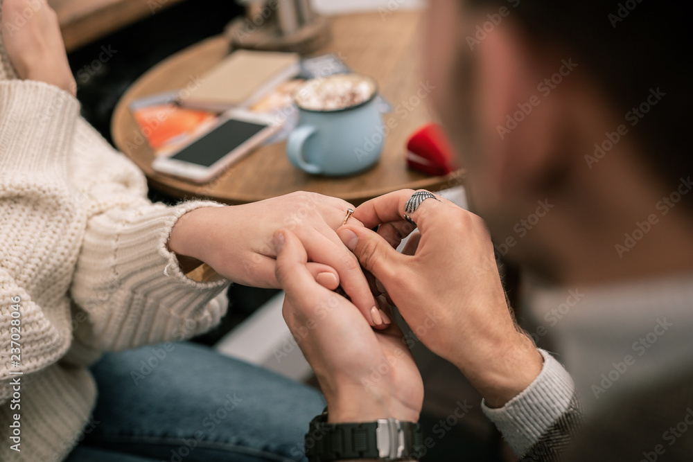 Man putting a ring on his girlfriends finger