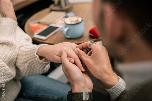 Man putting a ring on his girlfriends finger
