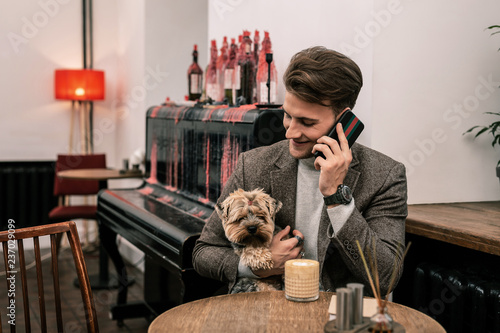 Man with a dog waiting for an important meeting in a cafe photo