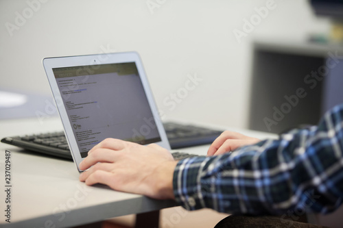 Close-up of male hands using laptop at office, man