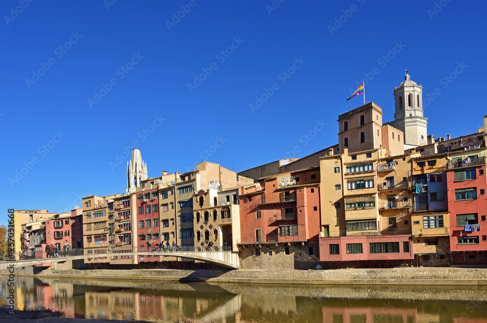 colorful houses facing the river Onyar and Catathedral and Sant Feliu Church, Girona, Catalonia, Spain