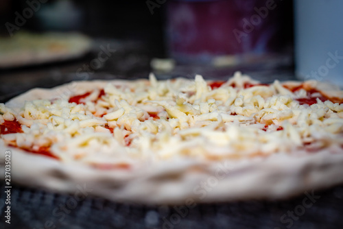 A raw pizza prepared to be cooked in the oven, closeup