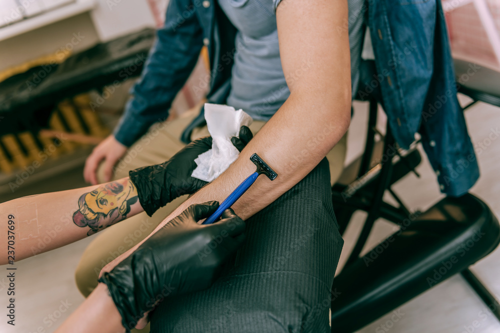 Tattoo master carrying disposable razor and using it for area Tattoo master carrying disposable razor and using it for area