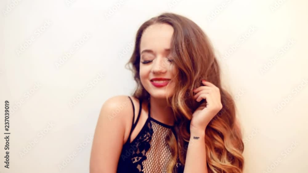 Girl with long curly hair posing . Model with perfect make up red lips and long eyelashes. Woman in black dress. Super cut girl in beautyful eyelashes. Girl smile. Girl with long curly hair posing . Model with perfect make up red lips and long eyelashes. Woman in black dress. Super cut girl in beautyful eyelashes. Girl smile.
