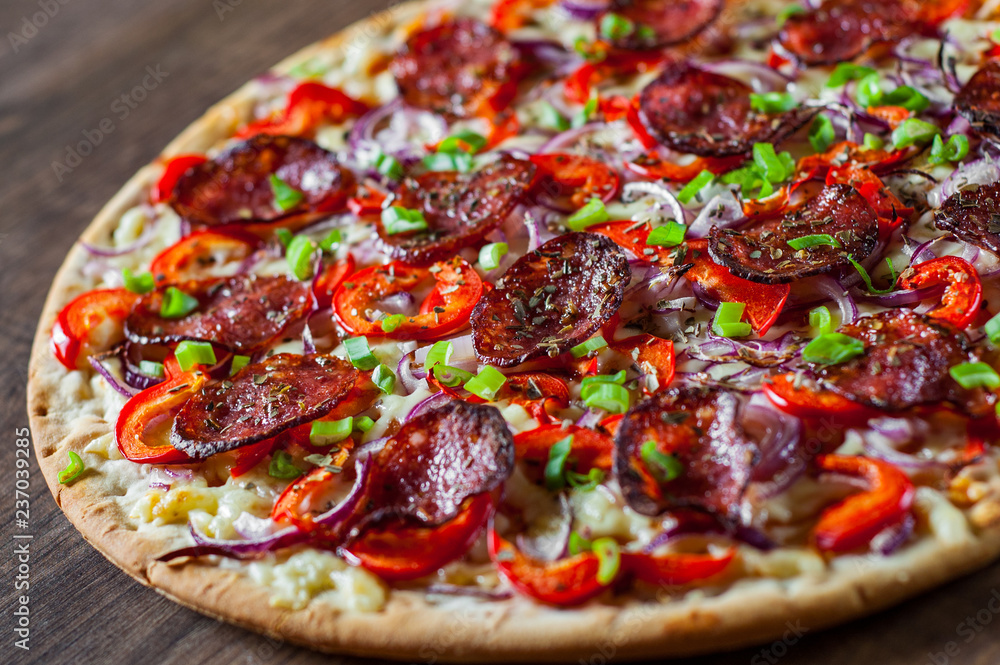 Pepperoni Pizza with Mozzarella cheese, salami, Tomato sauce, pepper, onion, Spices. Italian pizza on wooden table background Pepperoni Pizza with Mozzarella cheese, salami, Tomato sauce, pepper, onion, Spices. Italian pizza on wooden table background