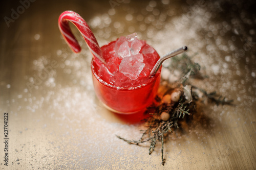 Top view on the christmas cocktal in red cup decorared with candy near the fir-tree branch photo