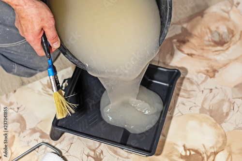construction worker prepares the glue for Wallpaper