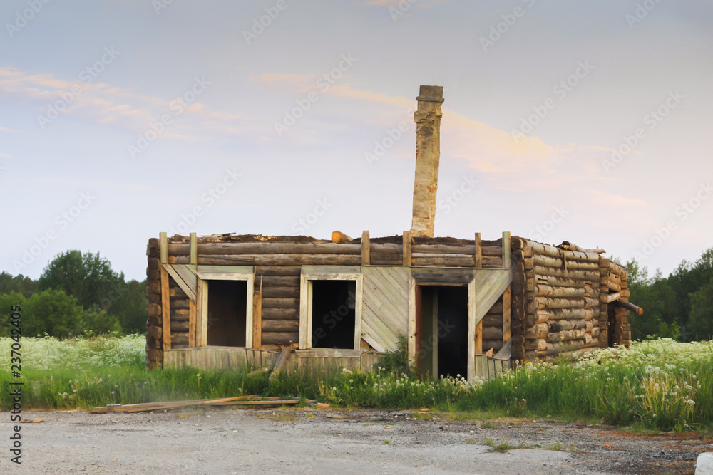 old wooden half built russian house izba without roof and brick chimney pipe growing from center. abandoned building without windows and door old wooden half built russian house izba without roof and brick chimney pipe growing from center. abandoned building without windows and door