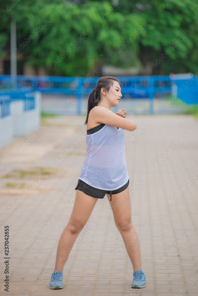 Asian sporty woman stretching body breathing fresh air in the park,Thailand people,Fitness and exercise concept,Jogging in the track,Fat girls want to thin. Asian sporty woman stretching body breathing fresh air in the park,Thailand people,Fitness and exercise concept,Jogging in the track,Fat girls want to thin.