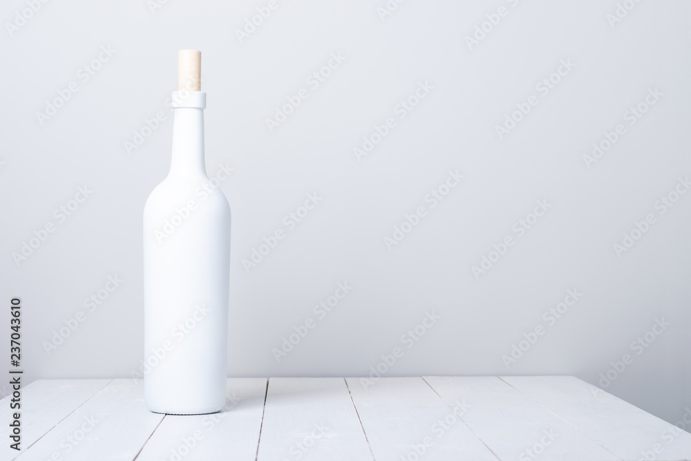 Red wine bottle on a white wooden background