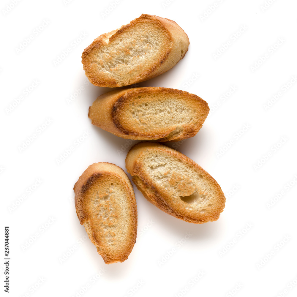 Toasted baguette slices isolated on white background close up. Toast, crouton. Top view. Toasted baguette slices isolated on white background close up. Toast, crouton. Top view.
