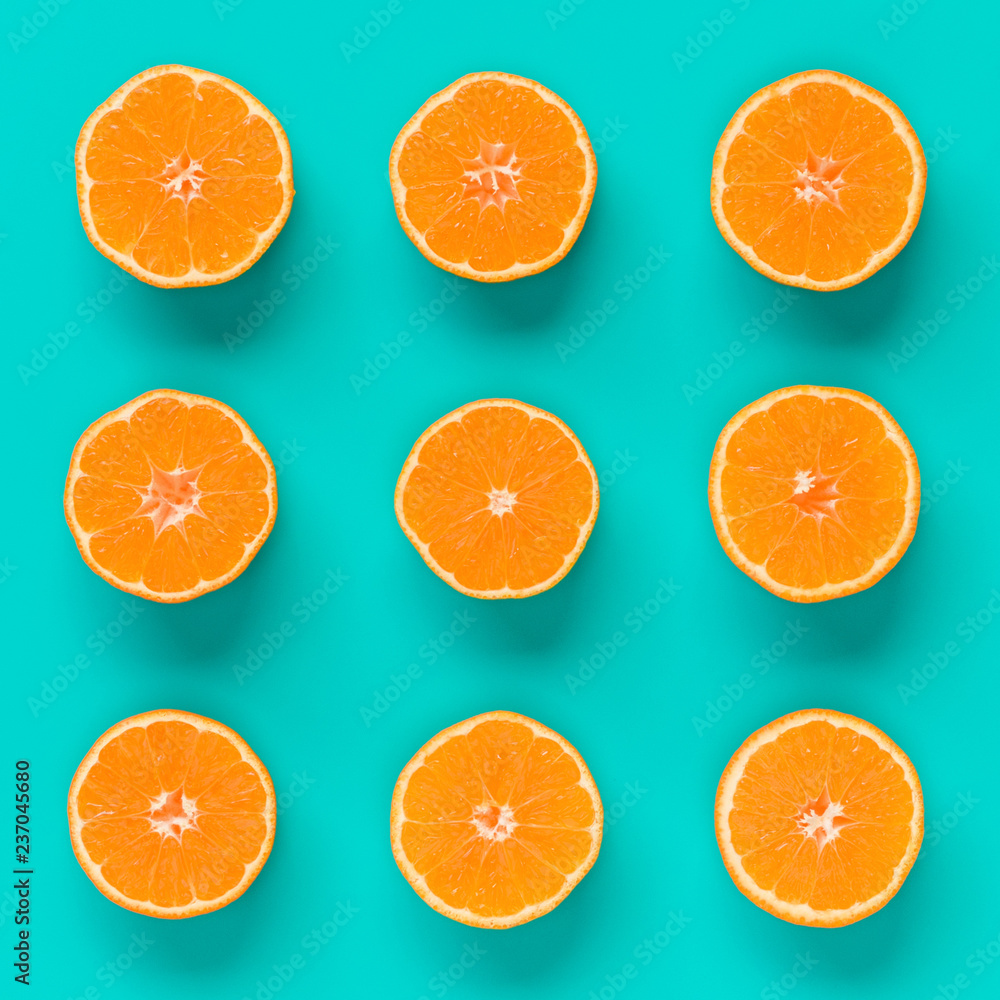 Fruit pattern of fresh mandarin slices on blue background. Flat lay, top view. Pop art design, creative summer concept. Half of citrus in minimal style. Tangerine. Fruit pattern of fresh mandarin slices on blue background. Flat lay, top view. Pop art design, creative summer concept. Half of citrus in minimal style. Tangerine.