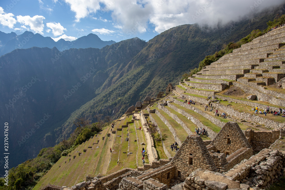 Panorama of Machu Picchu terraces, watcher's hut and Wuayna Picchu with shadow in early morning light. Machu Picchu is the famous lost city of the Incas near the river Urubamba located in the region