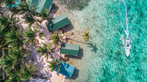 Foto Aerial drone view of Tobacco Caye small Caribbean island with palm trees and bun