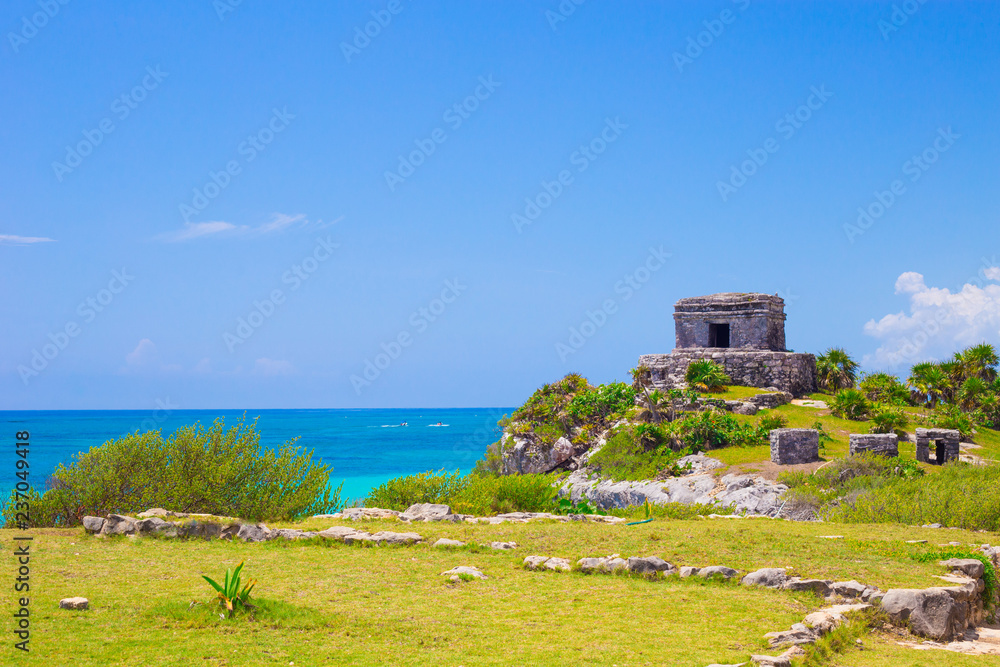 Tulum Maya Ruins with green grass and leafs with caribbean sea in background in Yucatan Mexico
