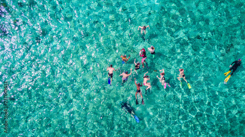 Aerial drone view of group of people snorkelling in tropical blue waters in the Caribbean Sea