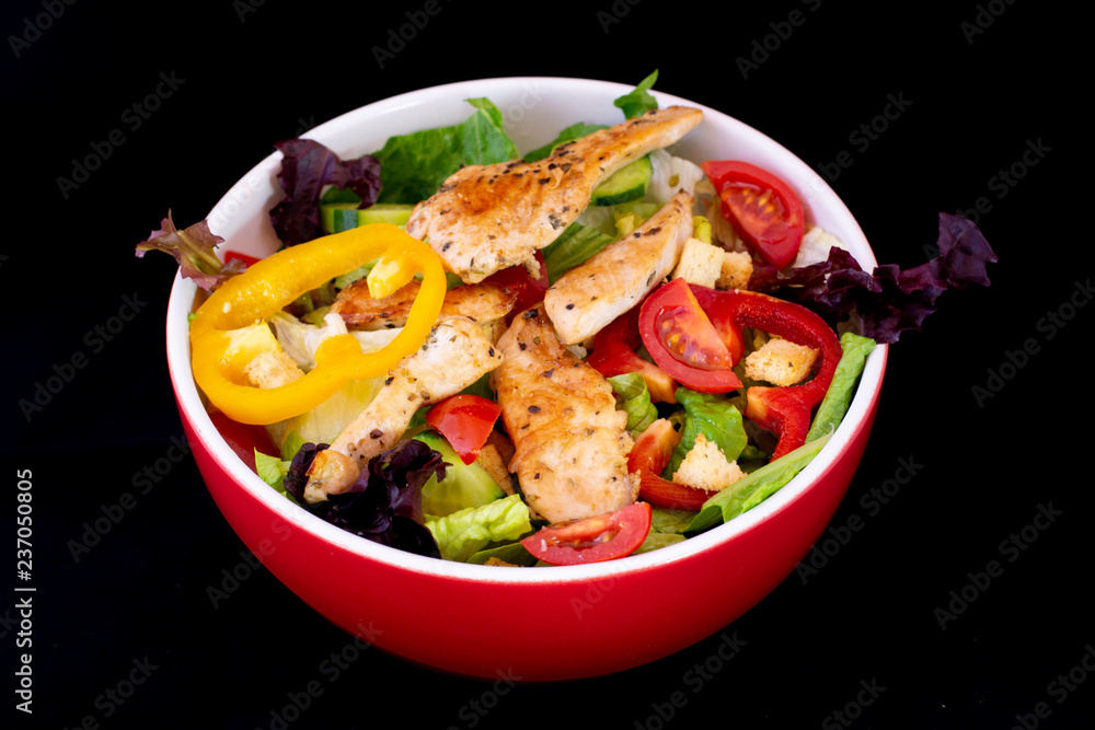Grilled Chicken Salad with fresh vegetables with isolated black background Grilled Chicken Salad with fresh vegetables with isolated black background