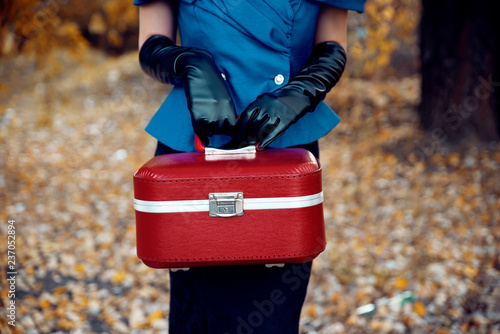 Lady in retro clothing holding red bag outdoors photo
