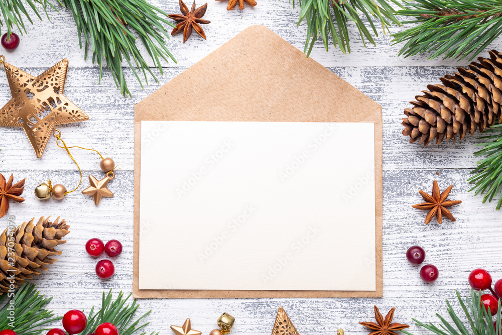 Fir branches, gifts and an envelope on a light wooden background. Cranberries, spices, holly berries. Fir branches, gifts and an envelope on a light wooden background. Cranberries, spices, holly berries.