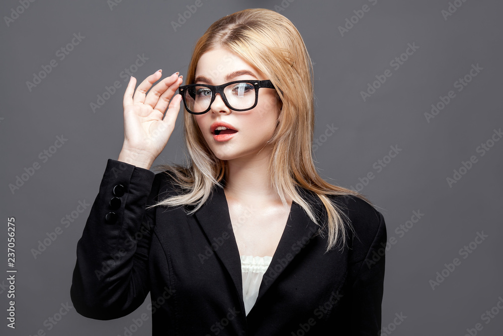 Smiling brunette woman in eyeglasses posing looking at the camera grey white background Smiling brunette woman in eyeglasses posing looking at the camera grey white background